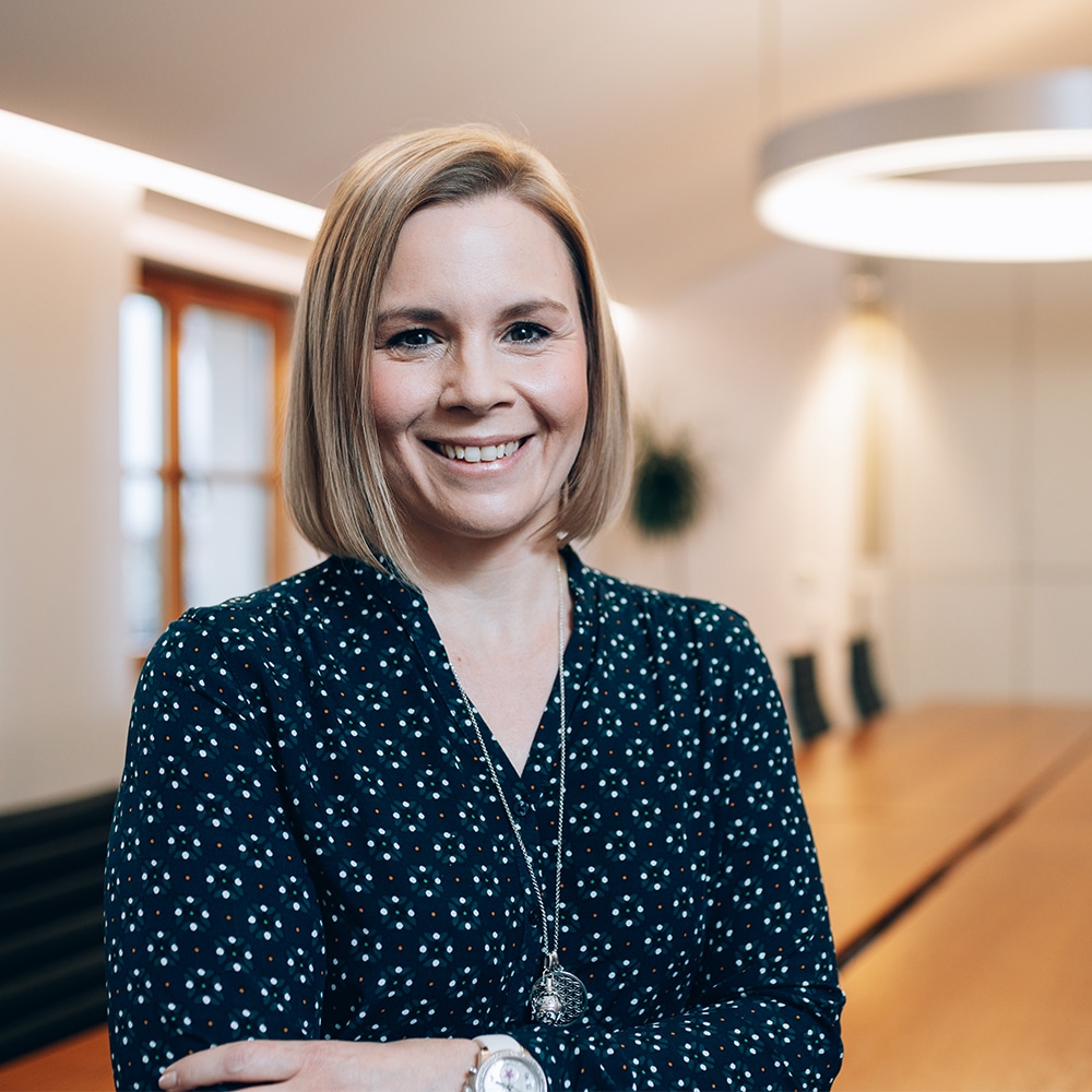 Frau strahlt und lächelt in die Kamera.