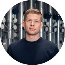 Junger Mann steht vor Rohrsystem